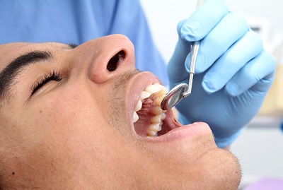 patient getting his teeth examined at dental clinic